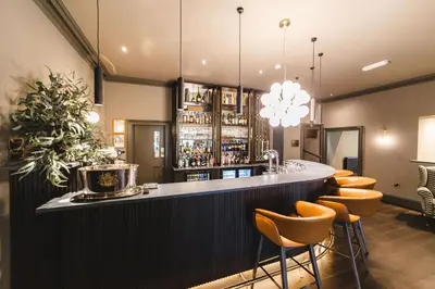 a bar with a bunch of stools around it at Borrowdale Gates Hotel in Keswick