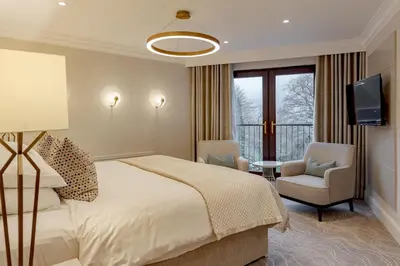 a hotel room with a bed and a balcony at Lodore Falls Hotel & Spa in Keswick