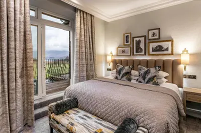 a bedroom with a bed and a large window at Lodore Falls Hotel & Spa in Keswick