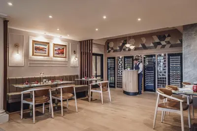 a man standing at a bar in a restaurant at Lodore Falls Hotel & Spa in Keswick