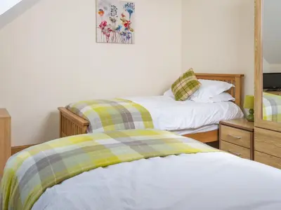two twin beds in a bedroom with a mirror at Seascape in Mainsriddle