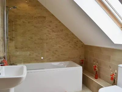 a bathroom with a white tub and a sink at Seascape in Mainsriddle