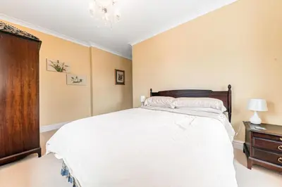 a bedroom with a large white bed and a dresser at Stickle Tarn in Keswick