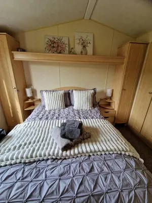 a bedroom with a large bed with towels on it at Lochview Retreat Caravan in Balminnoch