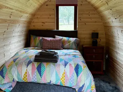 a bedroom with a bed in a wooden cabin at Howbeck Lodge in Hesket Newmarket