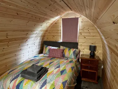 a bedroom with a bed in a log cabin at Howbeck Lodge in Hesket Newmarket