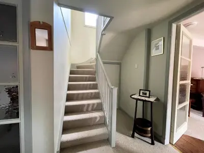 a staircase in a home with green walls at Charming Cosy Traditional Scottish Cottage - Pass the Keys in Castle Douglas