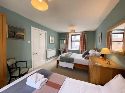 a hotel room with two beds and a desk and a desk at Charming Cosy Traditional Scottish Cottage - Pass the Keys in Castle Douglas