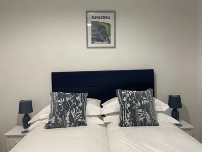 a bed with black and white pillows in a bedroom at Swallows Lodge in Keswick