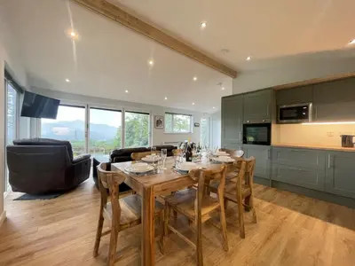 a kitchen and dining room with a table and chairs at Swallows Lodge in Keswick