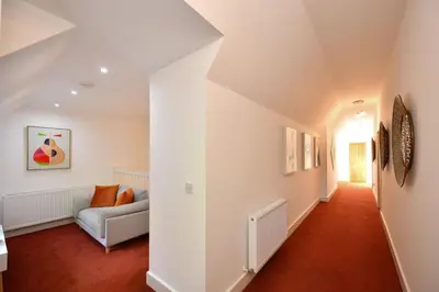 a living room with a couch and red carpet at 20 The Courtyard, Ballochmyle House in Mauchline