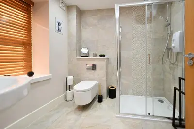 a bathroom with a shower and a toilet and a sink at 20 The Courtyard, Ballochmyle House in Mauchline
