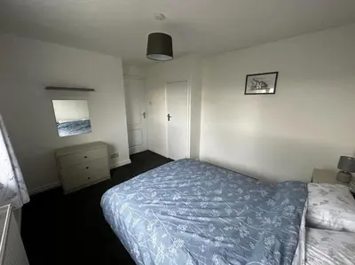 a bedroom with a bed with a blue comforter at Large 3 bed property in Whitehaven