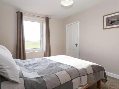 a bedroom with a bed and a window at 2 South Street in Wigton