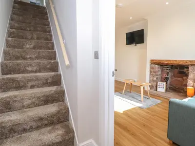 a staircase in a living room with a blue couch at 2 South Street in Wigton