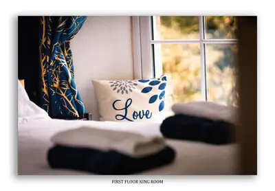 a bed with a pillow and a window with the words love at Clarefoot Cottage in Moffat