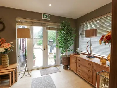 a living room with a large window and a wooden dresser at Scotia At The Pow in Annan