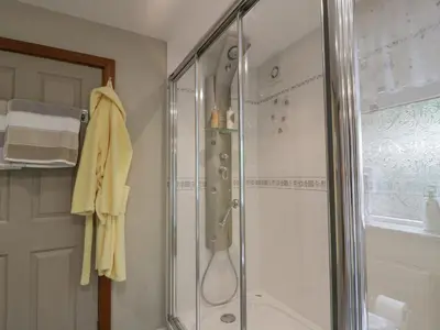 a bathroom with a shower with a glass door at Scotia At The Pow in Annan