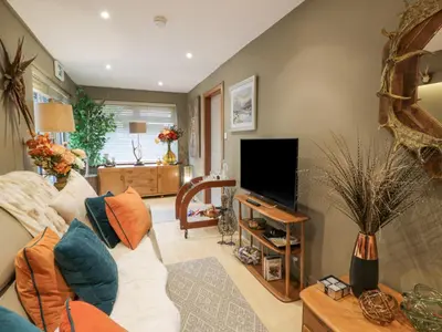 a living room with a couch and a flat screen tv at Scotia At The Pow in Annan