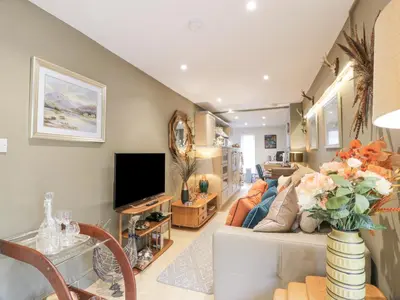 a living room with a couch and a tv at Scotia At The Pow in Annan