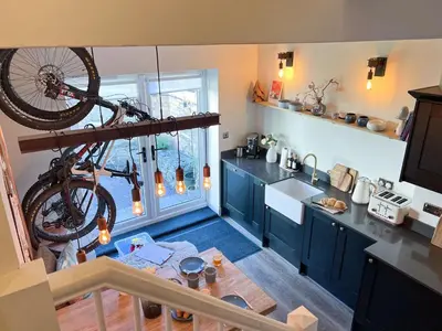 a kitchen with a bicycle hanging on the wall at Anley Cottage with garden and private parking in Keswick in Keswick