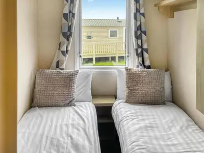 two beds in a small room with a window at Seaview 61-Uk46904 in Mainsriddle