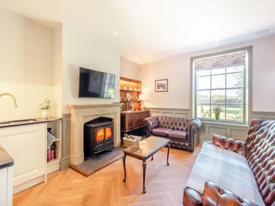 a living room with a couch and a fireplace at The Coach House in Longtown