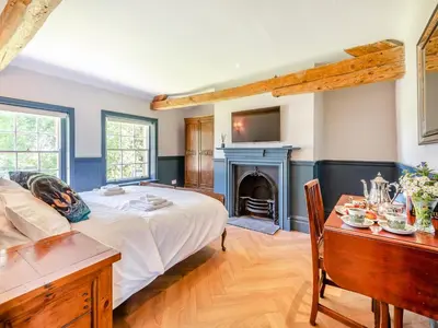 a bedroom with a bed and a fireplace at The Coach House in Longtown
