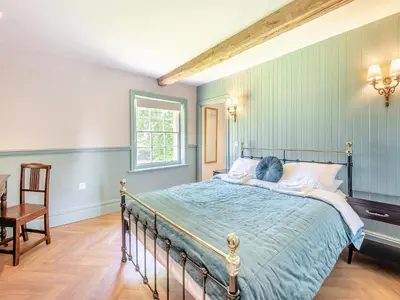 a bedroom with a bed with blue walls at The Coach House in Longtown