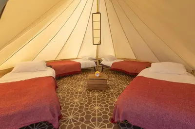 a room with three beds in a tent at Nine Yards Bell Tents at the TT - Douglas in Douglas