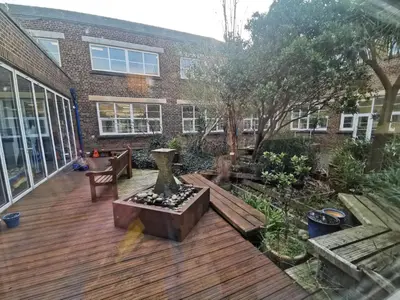 a patio with a wooden deck and a building at Nine Yards Bell Tents at the TT - Douglas in Douglas