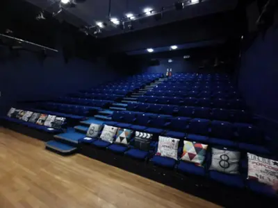 an empty auditorium with blue seats in a theatre at Nine Yards Bell Tents at the TT - Douglas in Douglas