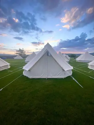 a group of white tents in a field at Nine Yards Bell Tents at the TT - Douglas in Douglas