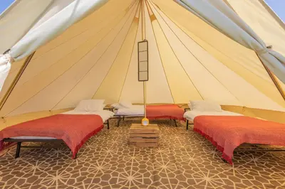 a marquee with three beds in a tent at Nine Yards Bell Tents at the TT - Douglas in Douglas