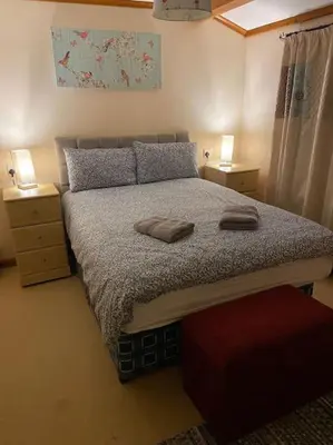 a bedroom with a large bed with two night stands at Livingstones Lodge, Lake District in Plumbland
