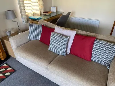 a couch with pillows on it in a living room at Livingstones Lodge, Lake District in Plumbland