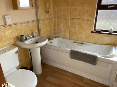 a bathroom with a sink and a tub and a toilet at Livingstones Lodge, Lake District in Plumbland
