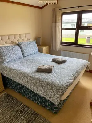 a bedroom with a bed with two towels on it at Livingstones Lodge, Lake District in Plumbland