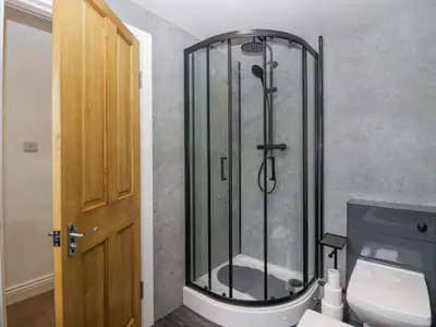a shower stall in a bathroom with a toilet at Victroneen Cottage in Whitehaven