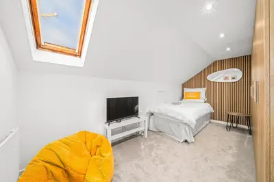 a small bedroom with a bed and a television at Perfect location for beach and golfing in Troon