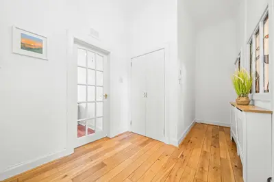 an empty hallway with white walls and wood floors at Perfect location for beach and golfing in Troon