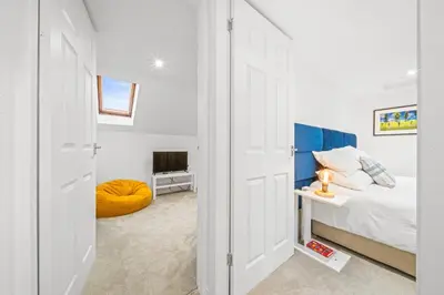 a small bedroom with a bed and a television at Perfect location for beach and golfing in Troon