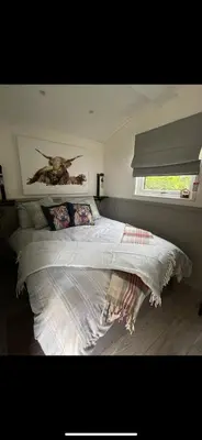 a bedroom with a bed with a painting on the wall at Millburn Mini Farm in Kilwinning