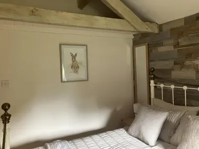 a bedroom with a bed and a picture on the wall at Annie's Cottage in Gosforth