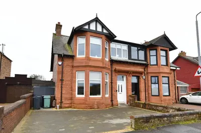 a house with a lot of windows on a street at Arran View in Prestwick in Prestwick