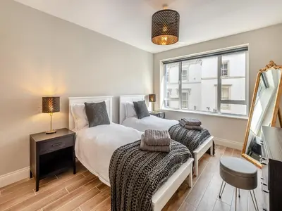 a bedroom with two beds and a window at Station Street Apartment in Cockermouth