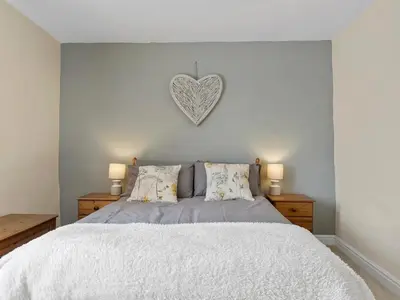 a bedroom with a bed with a heart on the wall at Newly Renovated 2 Bed Property - Pass the Keys in Cleator Moor
