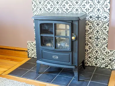 a blue wood stove in a room with a wall at Newly Renovated 2 Bed Property - Pass the Keys in Cleator Moor