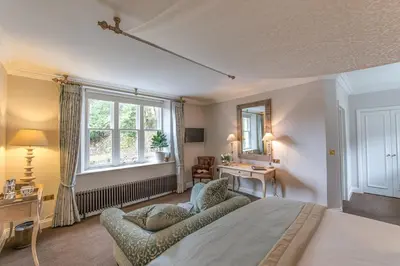 a bedroom with a bed and a couch and a window at Forest Side Hotel in Grasmere