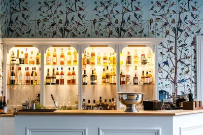 a bar with a lot of bottles of alcohol at Forest Side Hotel in Grasmere